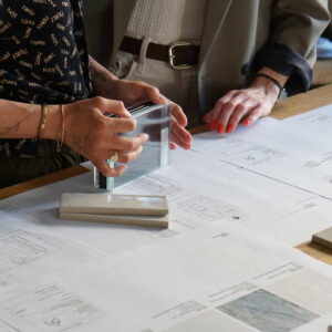 Händer och ritningar under projektledning av renovering.